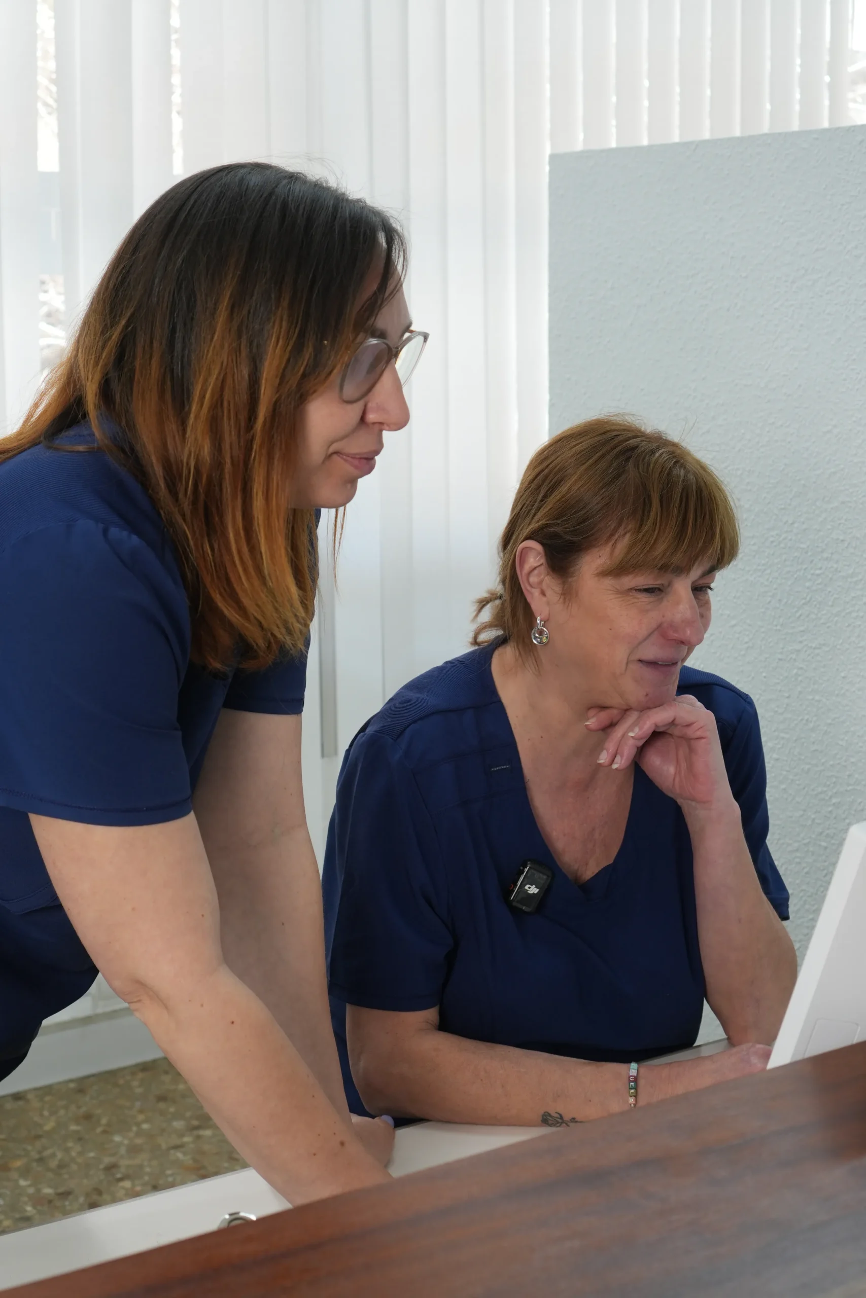 Virginia e Isabel del equipo de la clínica dental Dentelier en Alicante revisando un diagnóstico en la pantalla del ordenador.