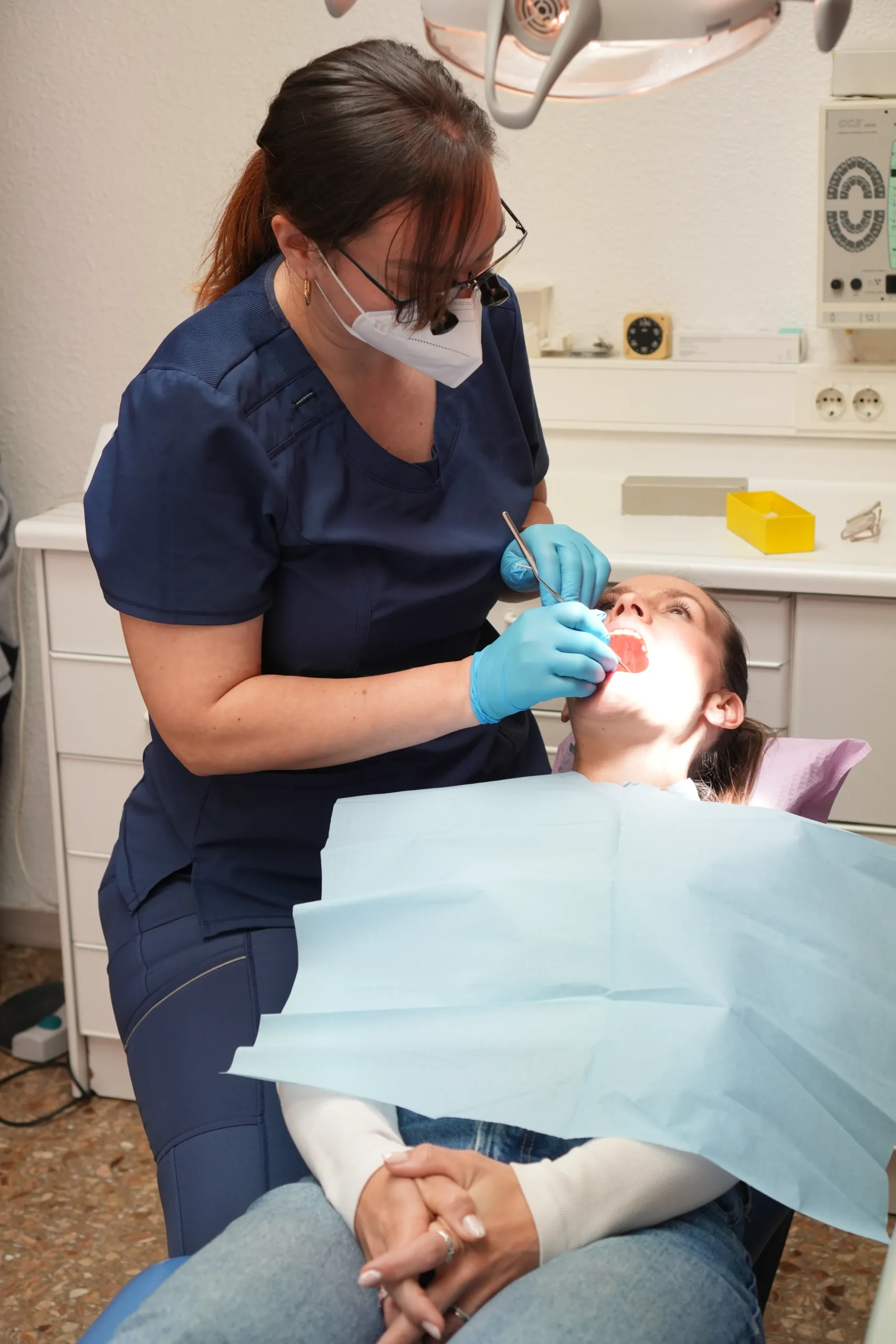 Odontóloga Virginia de la clínica Dentelier en Alicante realizando una revisión y tratamiento bucodental a una paciente en el sillón dental.